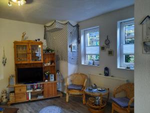 a living room with a tv and two chairs and a table at Ferienwohnung mit maritimen Flair in Lohme