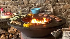 a large fire pit with food on a table at Lit et Croissants in Bertignat