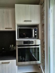 eine Mikrowelle in der Küche in der Unterkunft Le Cocon de Karine - maison Boulogne Sur Mer in Saint-Martin-Boulogne
