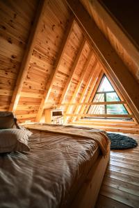 1 dormitorio en una cabaña de madera con una ventana grande en Colț de RAI A-Frame, en Drumu Carului