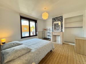 ein Schlafzimmer mit großem Bett und Kamin in der Unterkunft Le Cocon de Karine - maison Boulogne Sur Mer in Saint-Martin-Boulogne