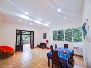a dining room and living room with a table and chairs at The serenity in Badulla