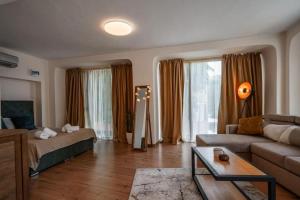 een woonkamer met een bank en een tafel bij Cozy studio with FRENCH WINDOWS in Plovdiv