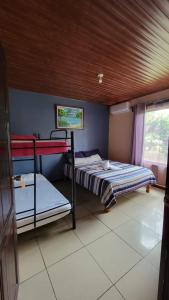 a bedroom with two bunk beds and a window at Hotel Campestre Arenal in Fortuna