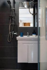 een badkamer met een witte wastafel en een spiegel bij Cozy studio with FRENCH WINDOWS in Plovdiv