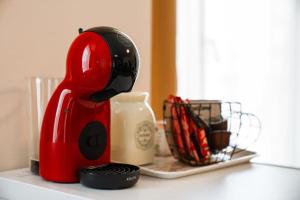 een rood apparaat op een aanrecht naast een blender bij Cozy studio with FRENCH WINDOWS in Plovdiv +26 foto's