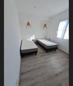 a room with two beds and a wooden floor at Maison de vacances à 500m de la mer in Santec