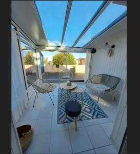 a screened in porch with a table and chairs at Maison de vacances à 500m de la mer in Santec +3 photos