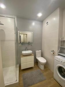 a bathroom with a toilet and a sink and a washing machine at Апартаменты CLASSIC в жк Империал in Truskavets +15 photos