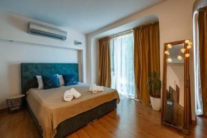 een slaapkamer met een groot bed met handdoeken erop bij Cozy studio with FRENCH WINDOWS in Plovdiv