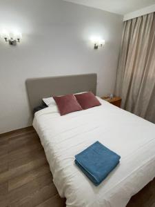 a white bed with a blue towel on it at Paris Appartement luxe inclus parking - Quai de la Seine -opéra 15mins in Paris