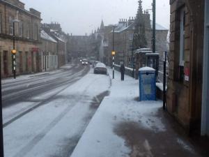 a city street filled with cars and snow at The Royal Hotel Tain in Tain