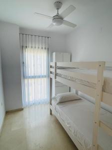 1 Schlafzimmer mit 2 Etagenbetten und einem Deckenventilator in der Unterkunft Paraiso de costa in Playa de Gandia + 12 Fotos