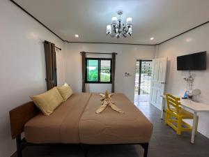 a bedroom with a large bed with a bow on it at Hanoii House in Ko Mak