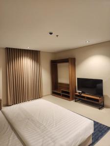 a bedroom with a bed and a flat screen tv at المهيدب للشقق الفندقية in Rabigh