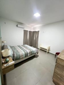 Un dormitorio con una cama, una mesa y un sofá. en DEPARTAMENTOS Del OESTE, en Villa Unión