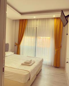 a bedroom with a bed with two towels on it at akdenız suıtes in Altınkum