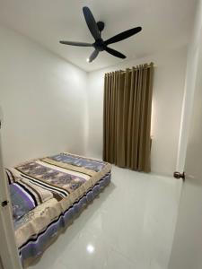 a bed in a room with a ceiling fan at Delisha Qistina Homestay Jalan Rantau Panjang Pasir Mas in Pasir Mas