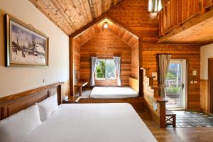 a bedroom in a log cabin with two beds at Aurora Villa in Renai