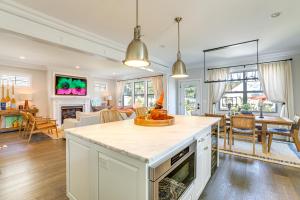 a kitchen and living room with a table and chairs at Sleek Long Branch Vacation Rental with Pool and Patio! in Long Branch