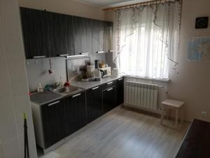 a kitchen with black cabinets and a sink and a window at Oti Guesthouse in Tallinn