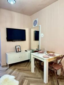 a living room with a table and a tv at The Studio At Athol House in London +5 photos