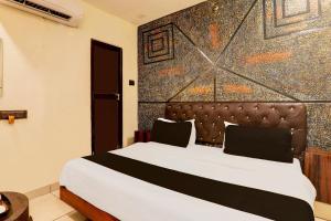 a bedroom with a bed with a large wall at Super Hotel O Sr Grand in Gorakhpur