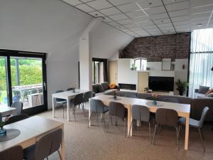 a meeting room with tables and chairs and a couch at Mariafarm in Zevenbergen