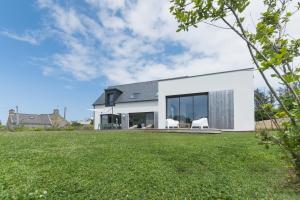 ein weißes Haus mit einem großen Hof in der Unterkunft Jolie Maison avec piscine intérieure à 5 minutes des plages in Landunvez