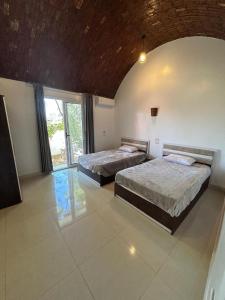 a bedroom with two beds and a large window at The House Of Love in Luxor