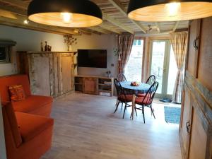 a living room with a table and chairs and a television at Stone Moor Lodge Justin's Peak District Base Camp in Sheffield