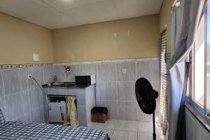 a small room with a bed and a microwave at Kitnet alojamento independente in Nova Iguaçu
