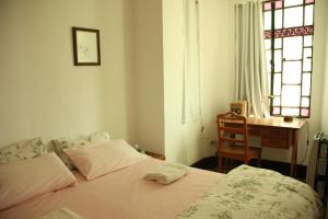 a bedroom with a bed and a desk and window at La Casona in La Plata