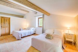 a bedroom with two beds and a window at 4 stars farmhouse, heated pool, view, 15 people in Bonnieux +25 photos