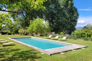 a swimming pool in a yard with lounge chairs at 4 stars farmhouse, heated pool, view, 15 people in Bonnieux