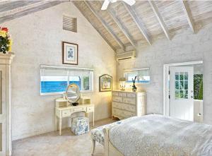 a bedroom with a bed and a desk and windows at Ocean Mist Villa 4Bd by ZenBreak in Saint Philip +14 photos