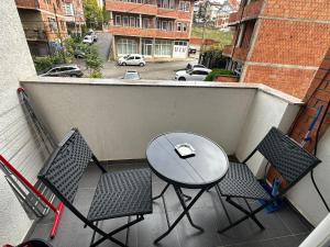 a balcony with a table and chairs and a street at Apartment Guri 1 in Pristina