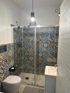 a bathroom with a shower with a toilet and a sink at White home Marzamemi in Marzamemi