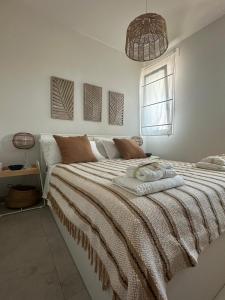 a white bedroom with a large bed with a blanket at White home Marzamemi in Marzamemi