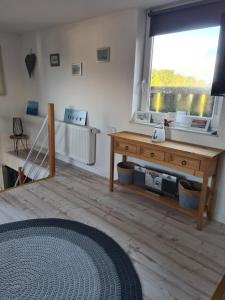 a living room with a wooden table and a window at Ferienwohnung Schnelzer in Sahlenburg