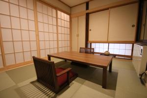 a room with a wooden table and a chair at Furano Shiyuirin in Kami-furano