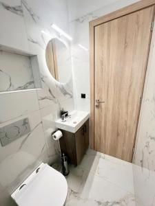 une salle de bain avec toilettes, lavabo et miroir dans l'établissement Ionia's Comfort Appartments -2nd floor, à Athènes