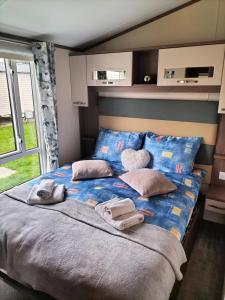 a bedroom with a bed with two towels on it at 3 bedroom caravan, Rhyl, Edi Rita, Robin Hood, Pet Friendly in Meliden