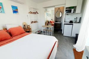 a bedroom with a white bed and a kitchen at Studio avec jardin et parking proche plages et Sainte-Musse in La Garde