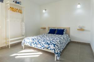 a bedroom with a bed with blue and white sheets at Vivienda vacacional Tinisagua 2 in Breña Alta