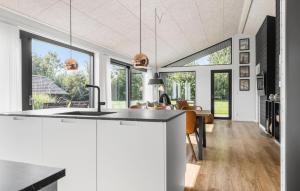 a kitchen and living room with a large window at 3 Bedroom Amazing Home In Sydals in Sarup