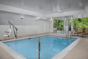 a pool with blue water in a building at Courtyard by Marriott Philadelphia Bensalem in Bensalem