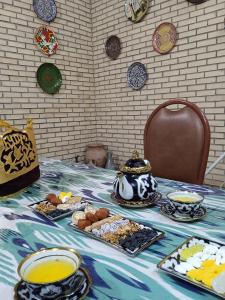 a table with plates of food on a table at Whole Guest House Rental In the Center of Tourism Area in Bukhara