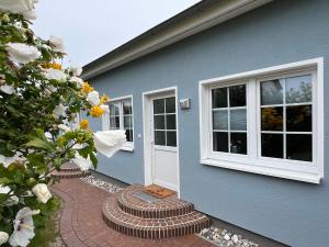 ein blaues Haus mit einem Backsteinsteg neben einer Tür in der Unterkunft Fewo Barth 2 in Barth