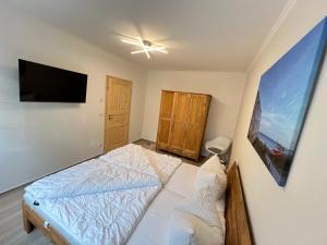 ein Schlafzimmer mit einem Bett und einem Flachbildfernseher in der Unterkunft Fewo Barth 2 in Barth